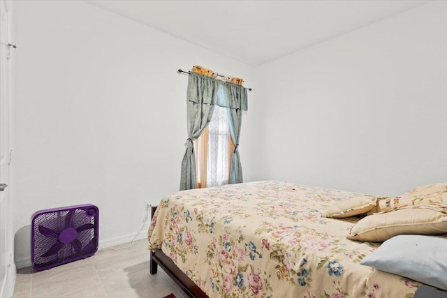 bedroom featuring light tile patterned floors and baseboards