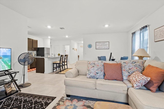 living room with light tile patterned flooring, visible vents, and recessed lighting