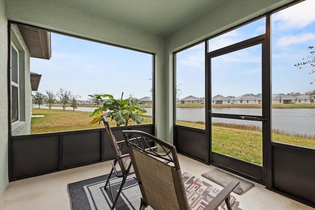 sunroom featuring a water view