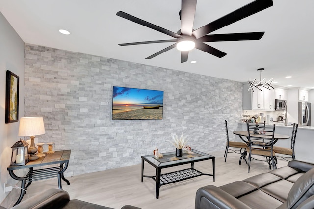 living room with ceiling fan with notable chandelier