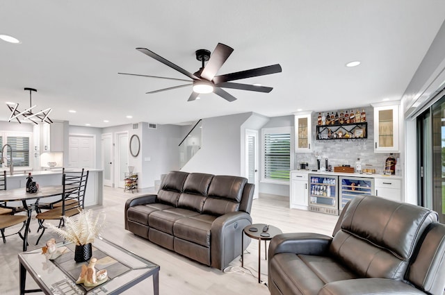 living room featuring bar, wine cooler, and ceiling fan