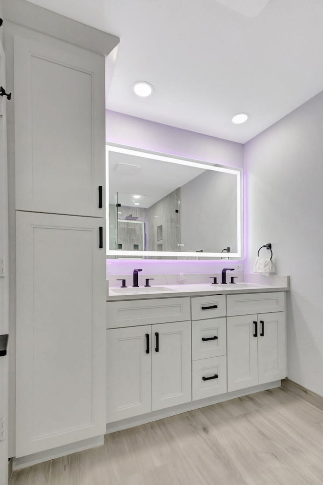 bathroom with vanity, hardwood / wood-style floors, and a shower with shower door