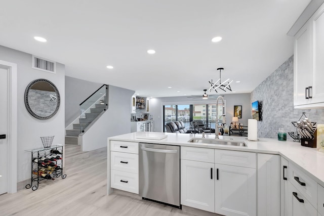 kitchen featuring dishwasher, hanging light fixtures, white cabinets, decorative backsplash, and kitchen peninsula