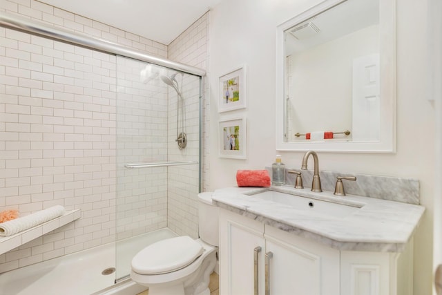 bathroom featuring vanity, toilet, and walk in shower