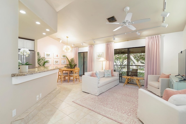 tiled living room featuring track lighting and ceiling fan with notable chandelier