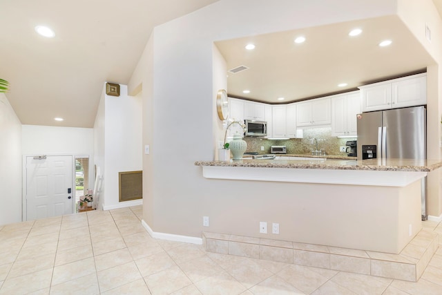 kitchen featuring light stone counters, appliances with stainless steel finishes, kitchen peninsula, and white cabinets