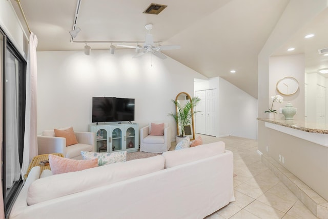 tiled living room featuring vaulted ceiling, ceiling fan, and track lighting