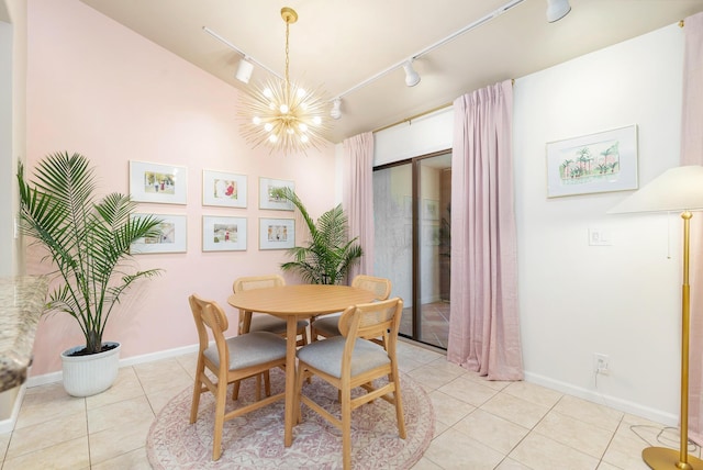 tiled dining space featuring a notable chandelier and track lighting