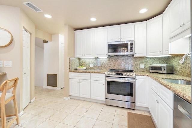 kitchen with appliances with stainless steel finishes, sink, and white cabinets