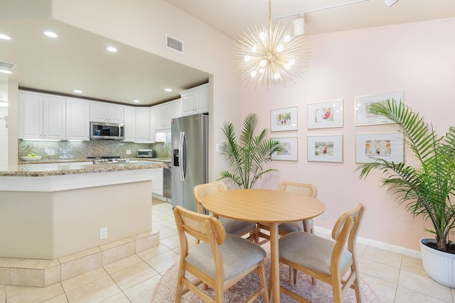 tiled dining space featuring an inviting chandelier