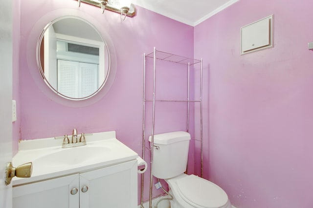 bathroom with vanity, ornamental molding, and toilet