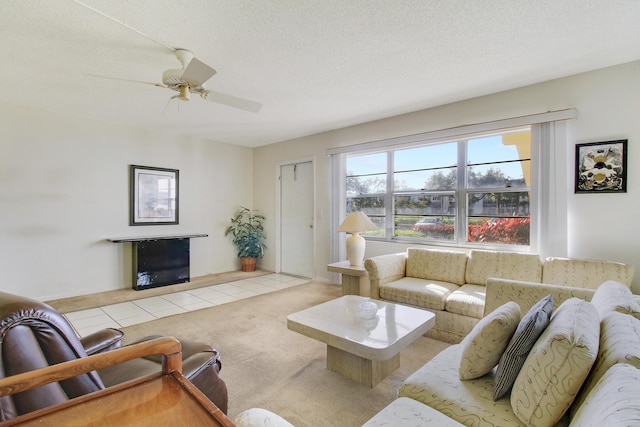 living room featuring ceiling fan, light carpet, and a textured ceiling