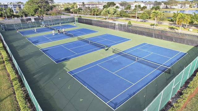 view of tennis court with a water view