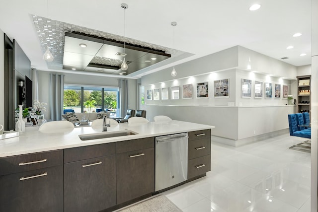 kitchen featuring a raised ceiling, dishwasher, sink, and pendant lighting