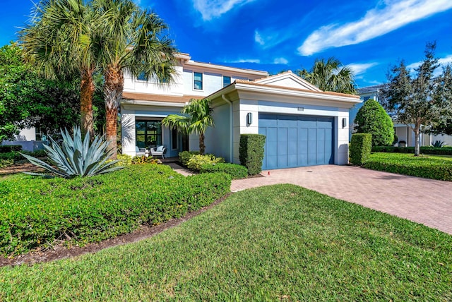 view of front of property with a garage and a front lawn