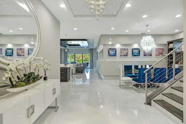 interior space featuring light tile patterned floors, a chandelier, and a tray ceiling