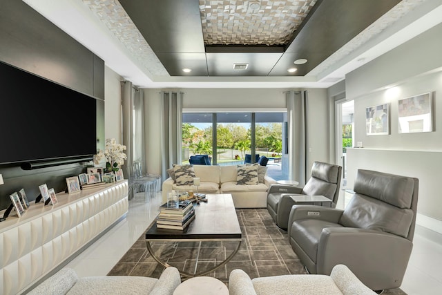 living room featuring dark tile patterned flooring and a raised ceiling