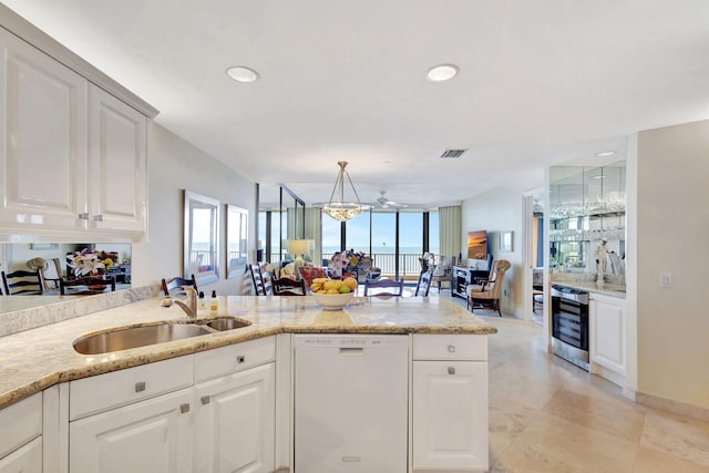 kitchen featuring white cabinetry, sink, white dishwasher, and decorative light fixtures