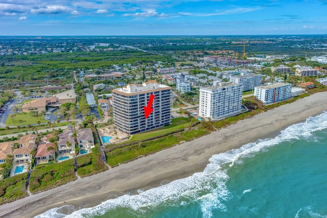 birds eye view of property featuring a beach view and a water view