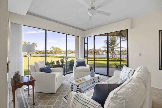 living room featuring a water view, a healthy amount of sunlight, and ceiling fan