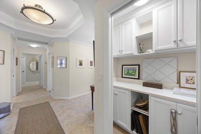 hallway featuring ornamental molding and a raised ceiling