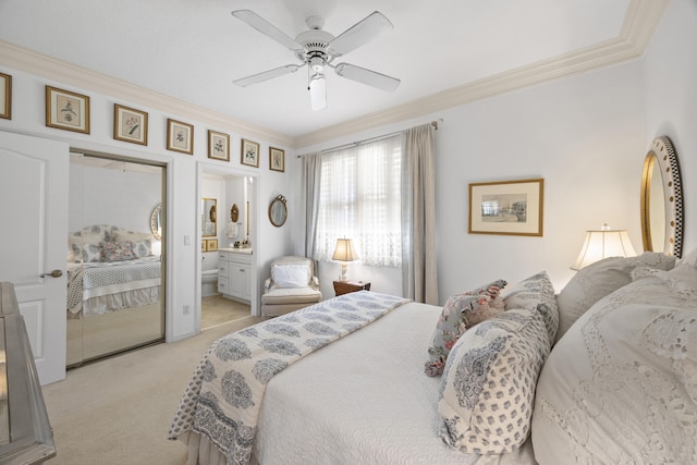 bedroom featuring crown molding, ceiling fan, ensuite bathroom, and light carpet