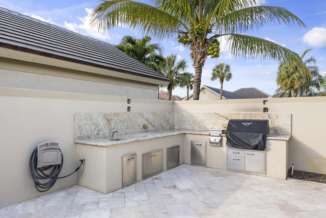 view of patio featuring exterior kitchen, a grill, and sink