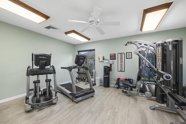 workout room featuring ceiling fan and light wood-type flooring