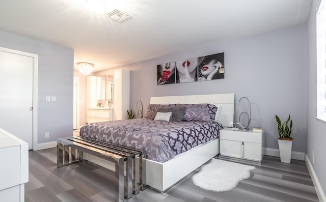 bedroom featuring connected bathroom and hardwood / wood-style floors