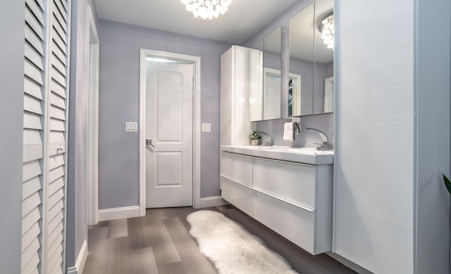 bathroom with hardwood / wood-style floors, a notable chandelier, and vanity