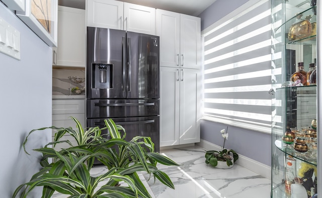 kitchen with stainless steel fridge with ice dispenser, white cabinetry, and plenty of natural light