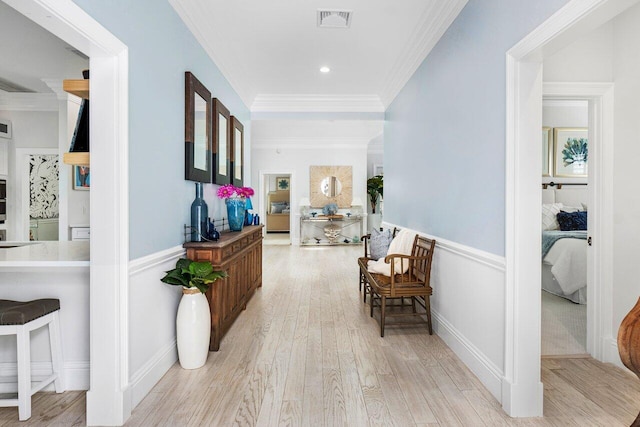 hallway with crown molding and light hardwood / wood-style floors