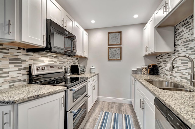 kitchen featuring appliances with stainless steel finishes, sink, white cabinets, and light stone counters