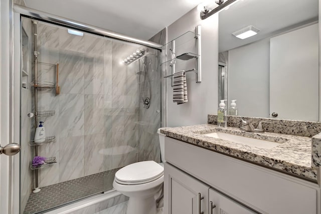 bathroom with walk in shower, vanity, and toilet