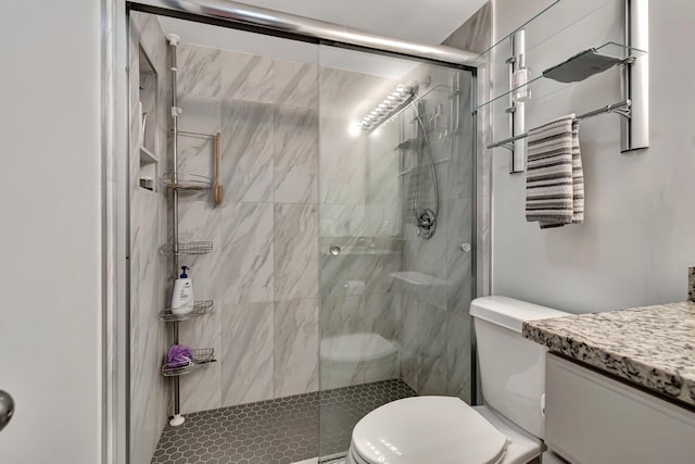 bathroom featuring vanity, toilet, and a shower with shower door