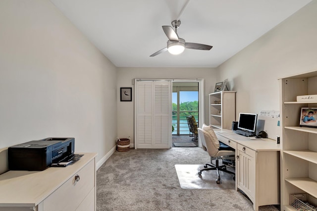 carpeted home office featuring ceiling fan