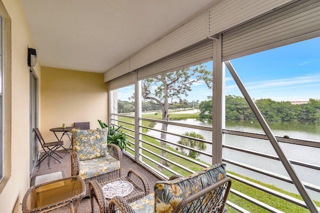 sunroom featuring a water view