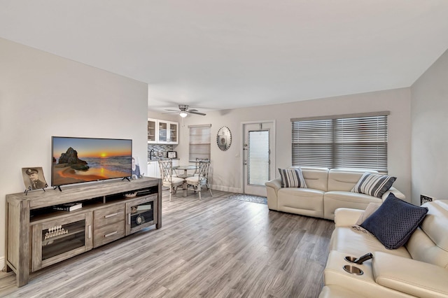 living room featuring wood-type flooring and ceiling fan