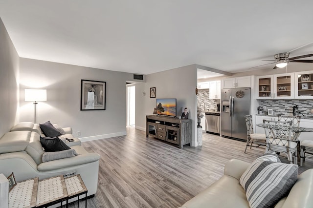 living room with ceiling fan and light hardwood / wood-style floors