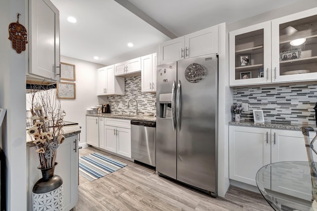 kitchen featuring light stone counters, appliances with stainless steel finishes, sink, and white cabinets