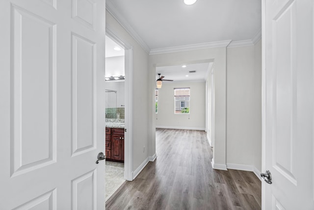 hall with ornamental molding and light hardwood / wood-style floors