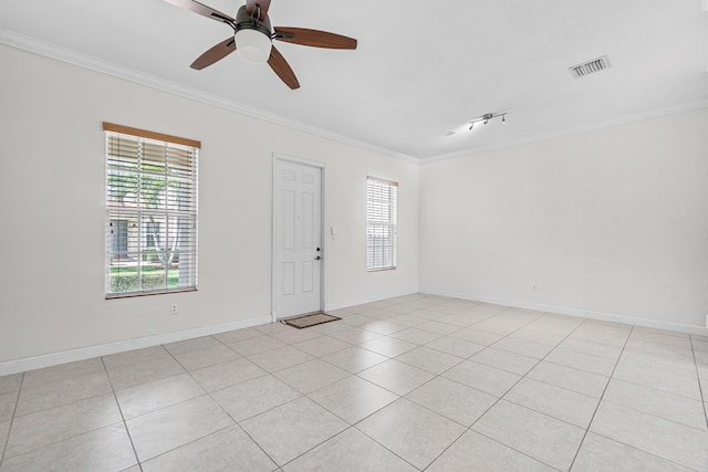 tiled empty room featuring ceiling fan, ornamental molding, and plenty of natural light