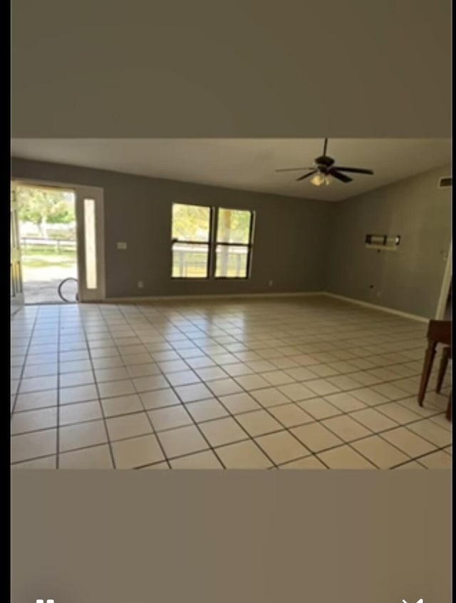 tiled spare room featuring plenty of natural light and ceiling fan