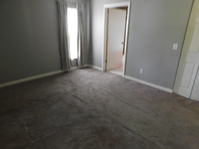 empty room with dark colored carpet