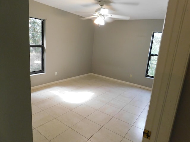 tiled spare room featuring ceiling fan and plenty of natural light