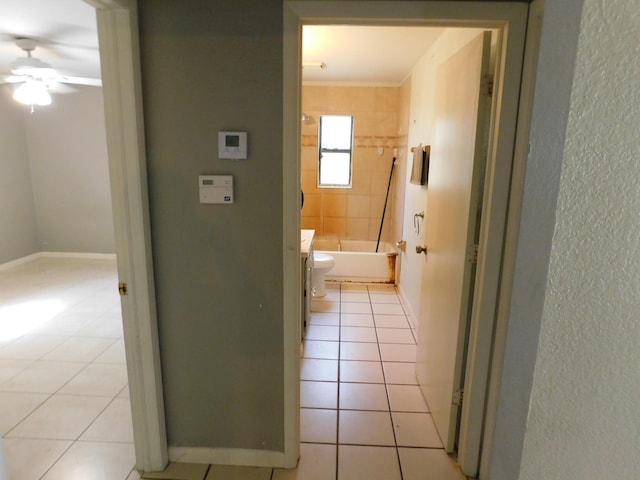 corridor with crown molding and light tile patterned floors