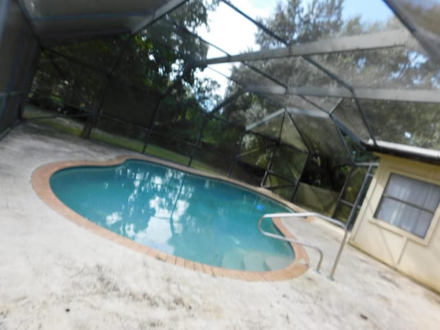 view of pool featuring a patio and glass enclosure