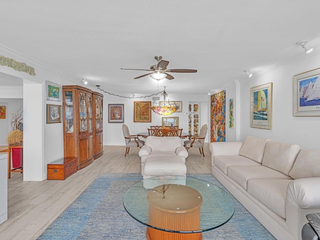 living room featuring ceiling fan, ornamental molding, and light wood-type flooring