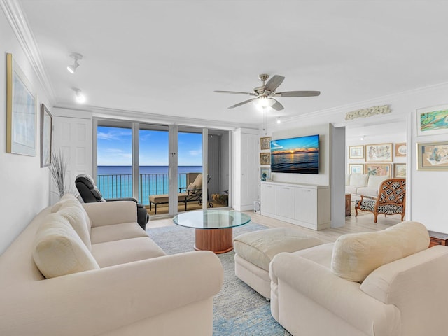 living room featuring crown molding, ceiling fan, and expansive windows