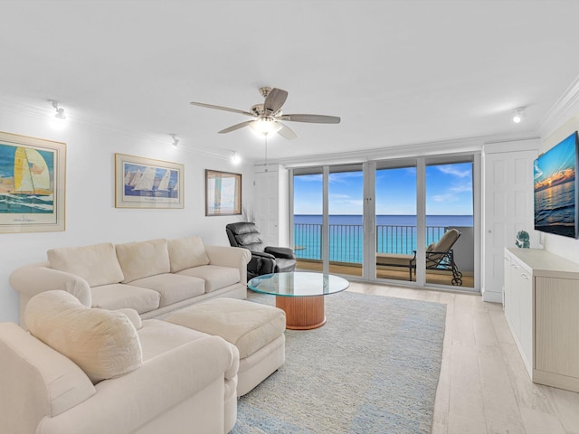 living room featuring crown molding, ceiling fan, a wall of windows, and light wood-type flooring